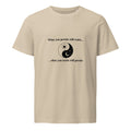 Desert-dust beige organic cotton t-shirt with a yin‑yang graphic and the quote "What you persist will resist... what you resist will persist" on the front.